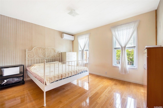 bedroom featuring a wall mounted air conditioner and wood-type flooring