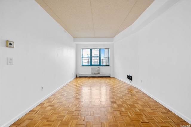 unfurnished room with a textured ceiling, vaulted ceiling, light parquet floors, and baseboard heating