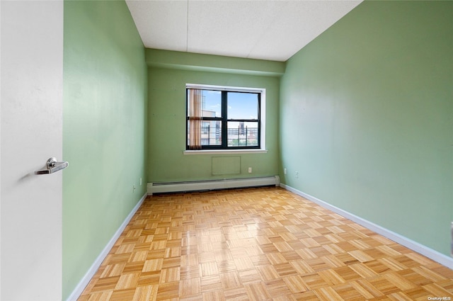 spare room featuring light parquet flooring and a baseboard heating unit