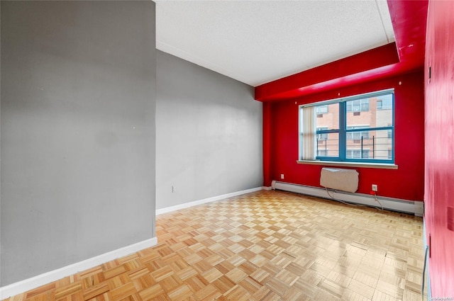 empty room with light parquet floors, a textured ceiling, and a baseboard heating unit