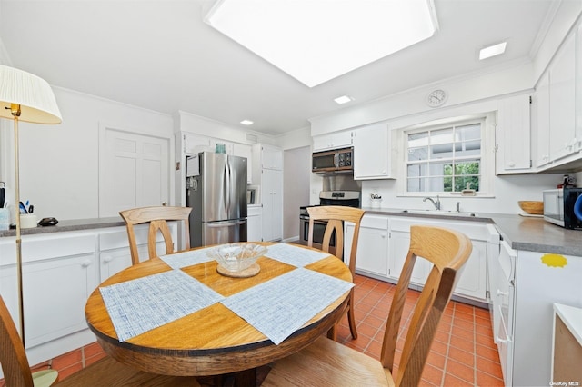 tiled dining room with sink and ornamental molding