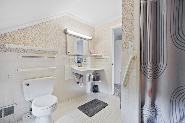 bathroom with tile patterned floors, crown molding, tile walls, and vaulted ceiling