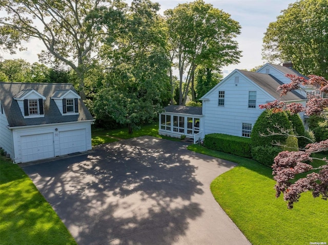 view of home's exterior featuring a yard, a garage, and a sunroom