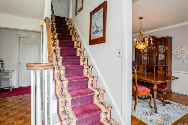 stairway featuring a notable chandelier, parquet flooring, and crown molding