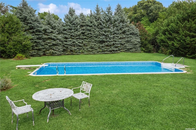 view of pool with a yard and a diving board