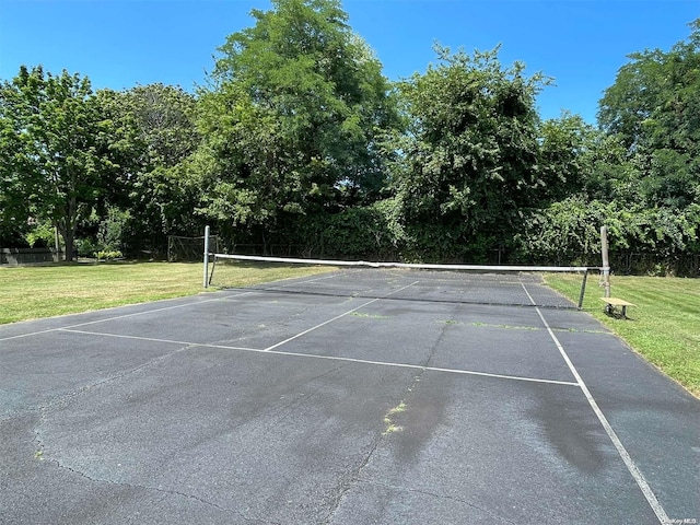 view of tennis court with a yard