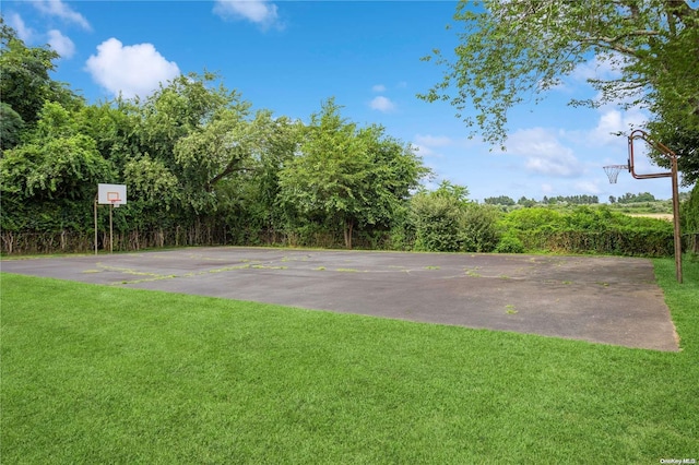 view of sport court with a yard