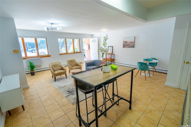 dining room with a chandelier, light tile patterned floors, and a baseboard heating unit