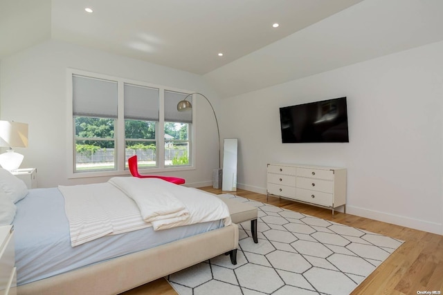 bedroom featuring light wood-type flooring and vaulted ceiling