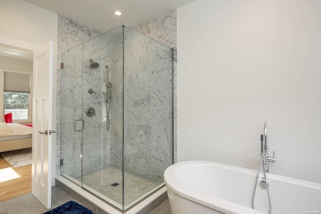 bathroom featuring tile patterned flooring and shower with separate bathtub