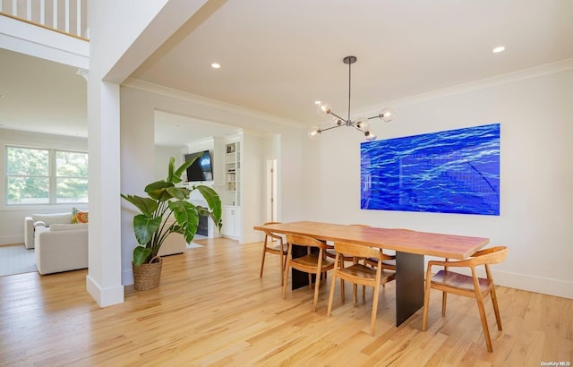 dining space with a chandelier, light wood-type flooring, and crown molding