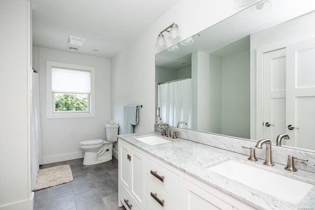 bathroom featuring tile patterned flooring, vanity, and toilet