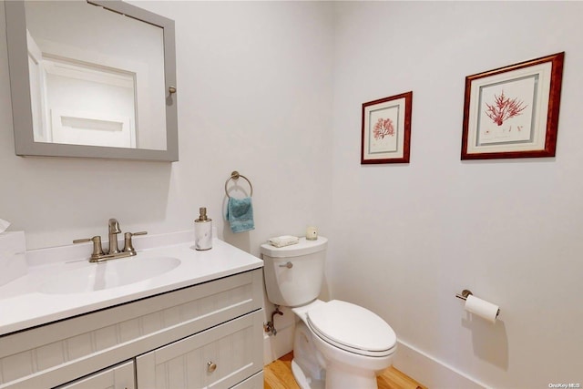 bathroom featuring vanity, wood-type flooring, and toilet