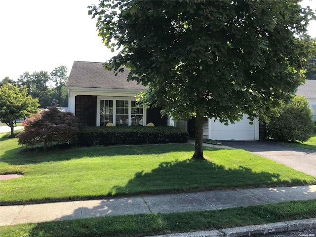 obstructed view of property with a front yard and a garage