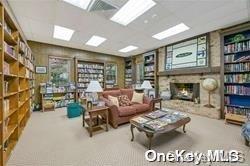 interior space with a stone fireplace and carpet