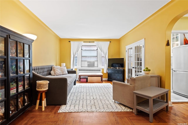 living room with cooling unit, radiator heating unit, parquet floors, and french doors