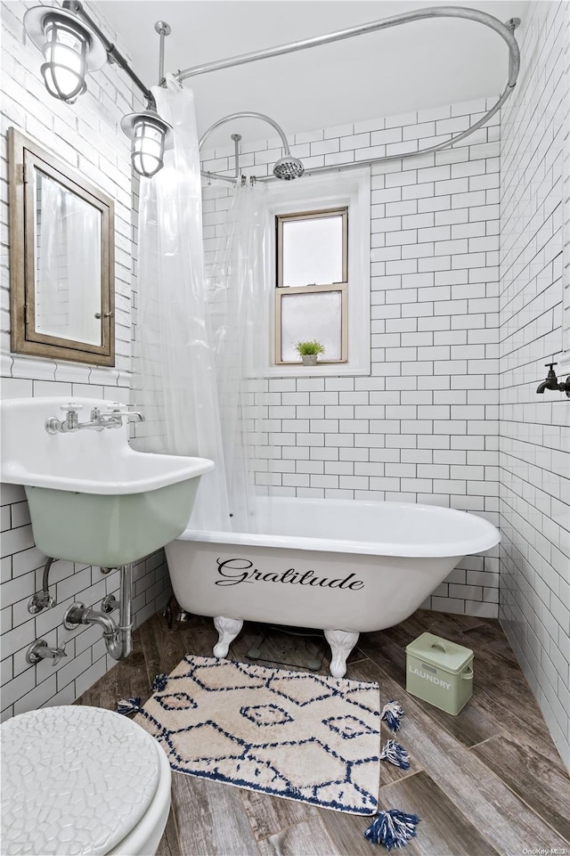 full bathroom with shower / bath combo, sink, hardwood / wood-style flooring, toilet, and tile walls