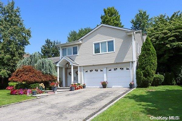 view of property featuring a front yard and a garage