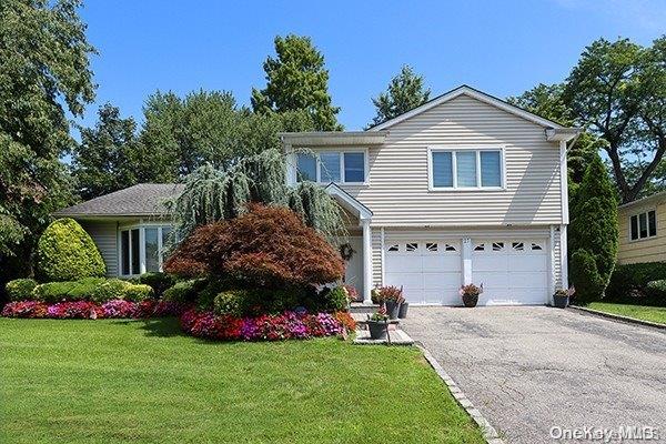 front facade with a front yard and a garage