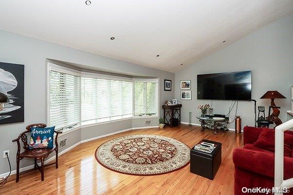 living room with lofted ceiling and wood-type flooring