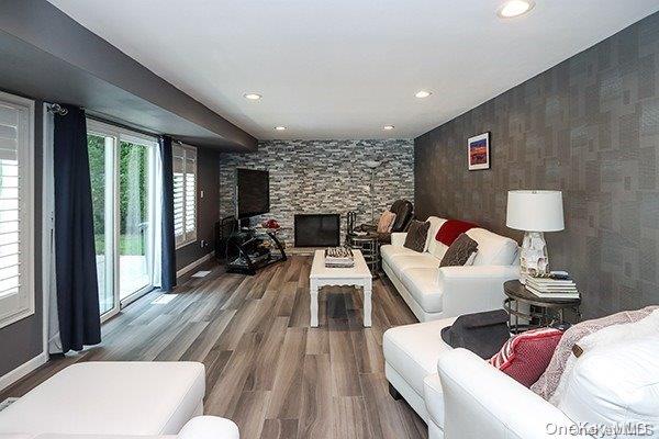 living room with a stone fireplace and hardwood / wood-style floors