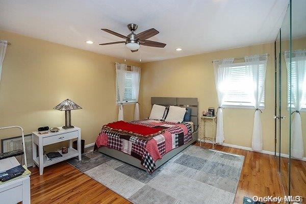 bedroom with wood-type flooring and ceiling fan