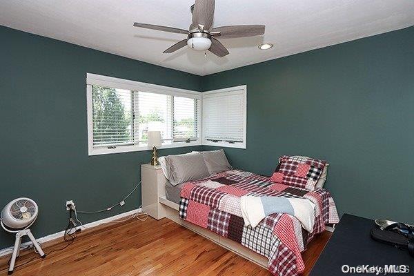 bedroom with ceiling fan and wood-type flooring