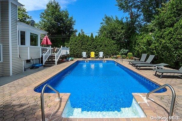 view of swimming pool featuring a deck and a patio area