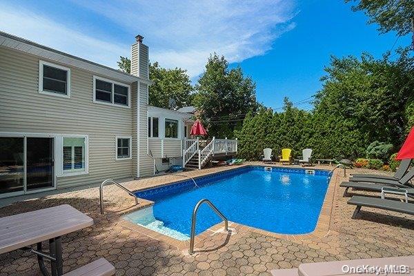 view of swimming pool featuring a deck and a patio