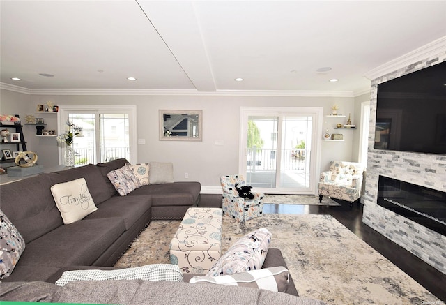 living room featuring ornamental molding, dark hardwood / wood-style flooring, a healthy amount of sunlight, and a fireplace