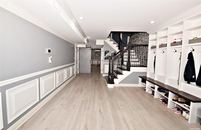 mudroom with light hardwood / wood-style flooring and ornamental molding