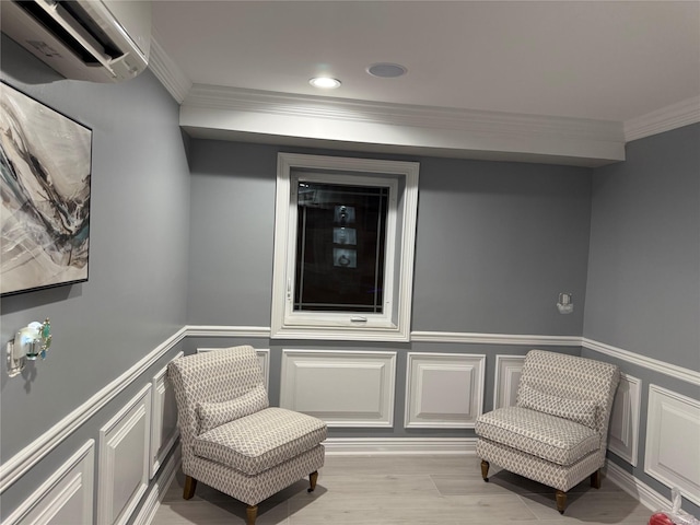 living area featuring a wall unit AC, ornamental molding, and light wood-type flooring