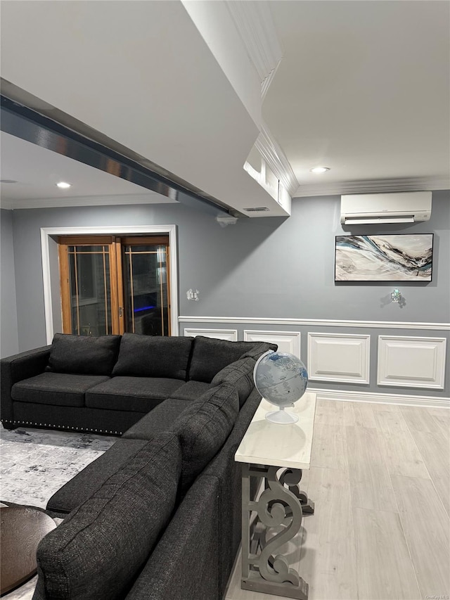 living room with a wall mounted AC, ornamental molding, and light hardwood / wood-style floors