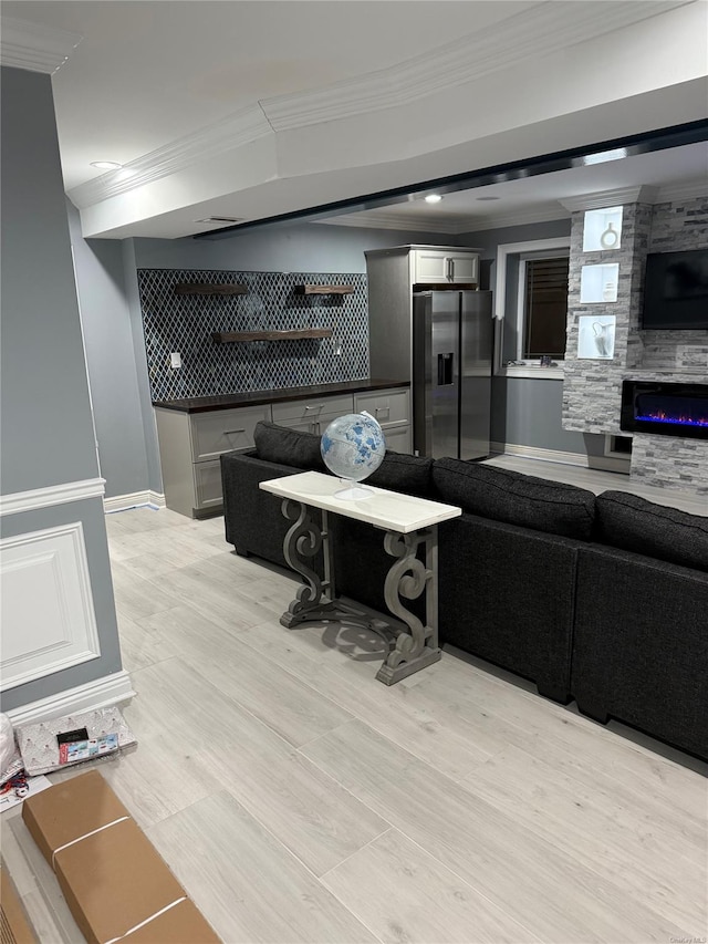 living room with light wood-type flooring and ornamental molding