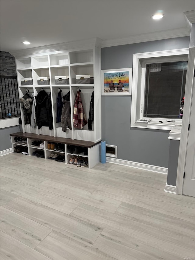 mudroom with light wood-type flooring and ornamental molding