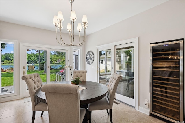 tiled dining room with a water view, beverage cooler, and a notable chandelier