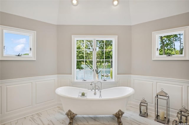 bathroom featuring vaulted ceiling and a tub