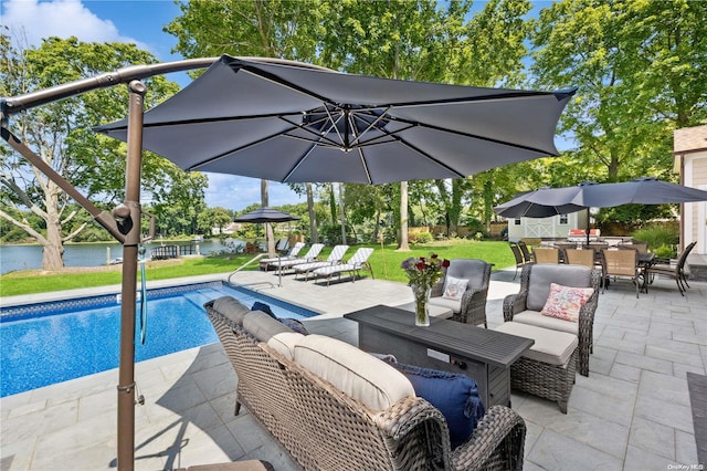 view of swimming pool featuring an outdoor living space, a patio area, a water view, and a yard