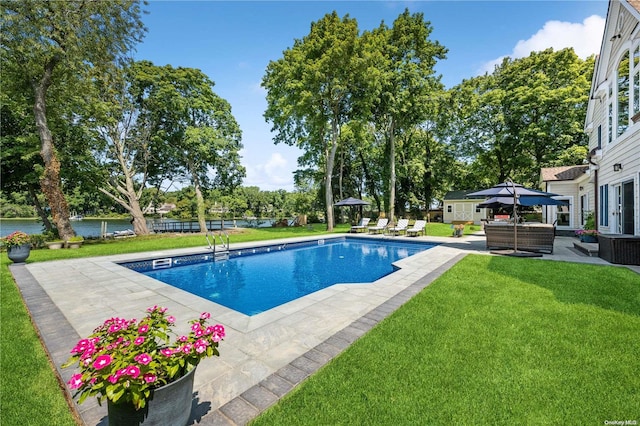 view of pool with a lawn, cooling unit, a patio area, and a water view
