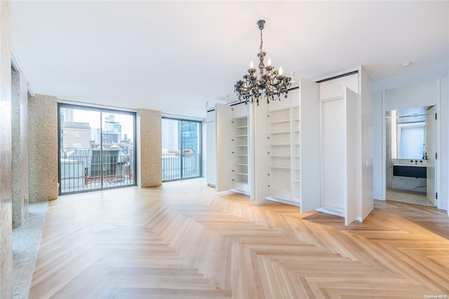 unfurnished room with expansive windows, light parquet floors, and an inviting chandelier