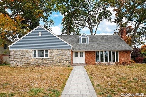 127 Berkshire Rd, Rockville Centre, NY 11570 - cape cod-style house with a front lawn, a chimney, and stone siding