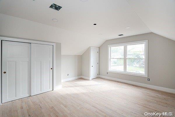 bonus room featuring light hardwood / wood-style flooring and vaulted ceiling