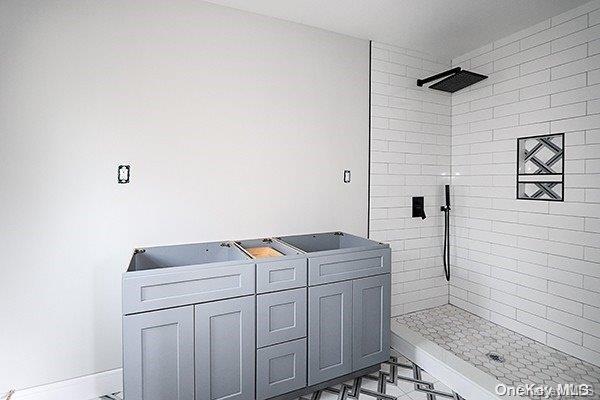 127 Berkshire Rd, Rockville Centre, NY 11570 - bathroom featuring tiled shower and baseboards