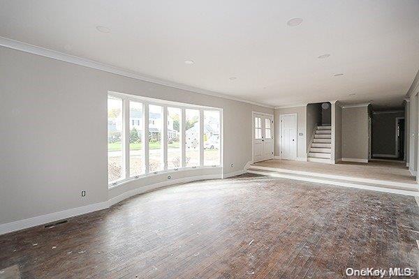 unfurnished living room with crown molding and dark hardwood / wood-style floors