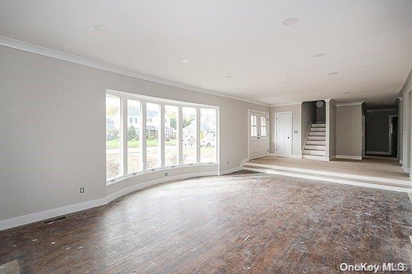 127 Berkshire Rd, Rockville Centre, NY 11570 - unfurnished living room featuring ornamental molding, wood finished floors, and stairs