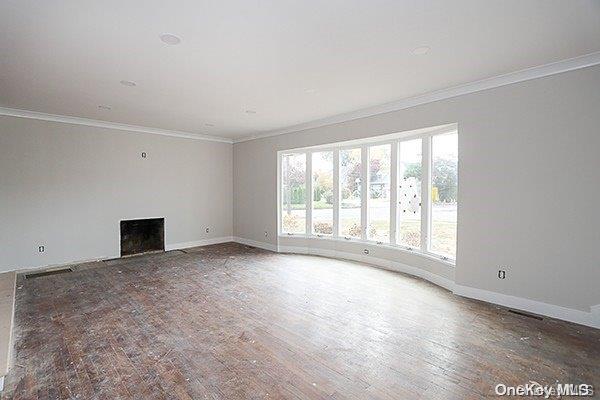 127 Berkshire Rd, Rockville Centre, NY 11570 - unfurnished living room featuring ornamental molding, wood finished floors, and a fireplace