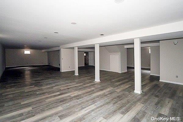 basement with dark hardwood / wood-style flooring