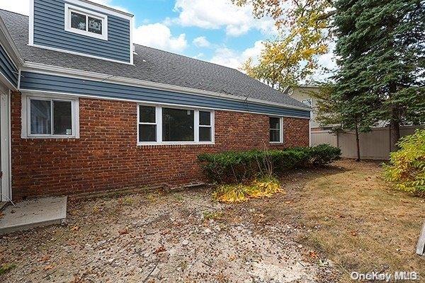 127 Berkshire Rd, Rockville Centre, NY 11570 - view of home's exterior with brick siding and roof with shingles