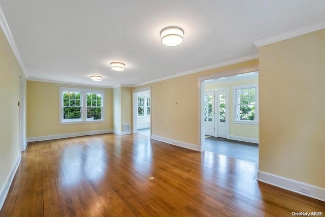 spare room featuring wood-type flooring and ornamental molding