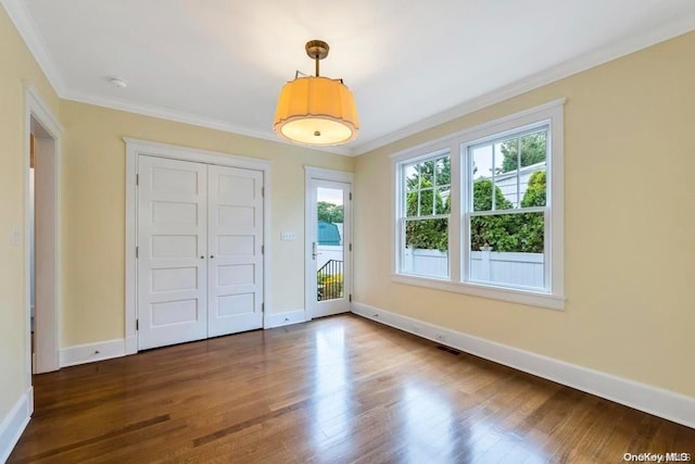 interior space with access to exterior, crown molding, and dark wood-type flooring